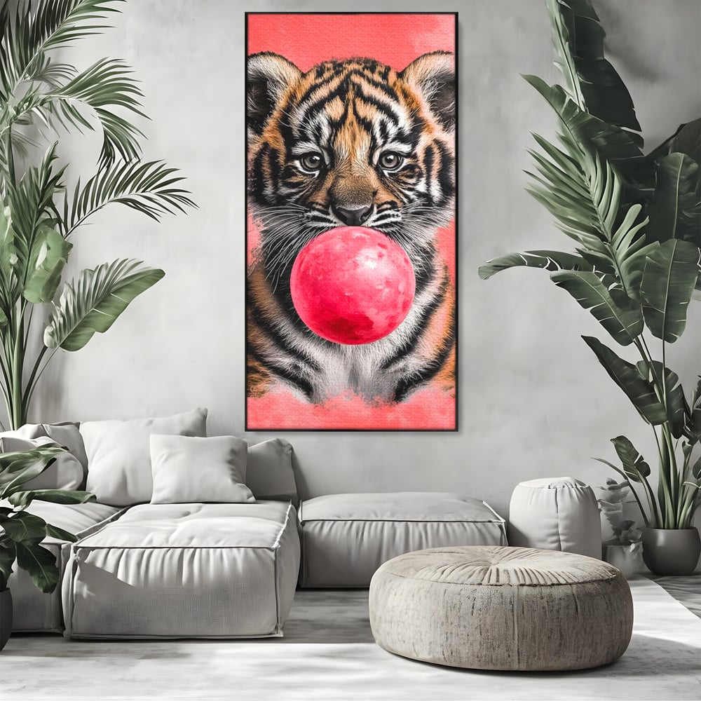Tablou canvas cu ilustratie pui de tigru cu guma roz, in rama de aluminiu negru, pe perete intr-un living